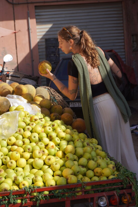 Girl choosing melons in the local souk in Anza