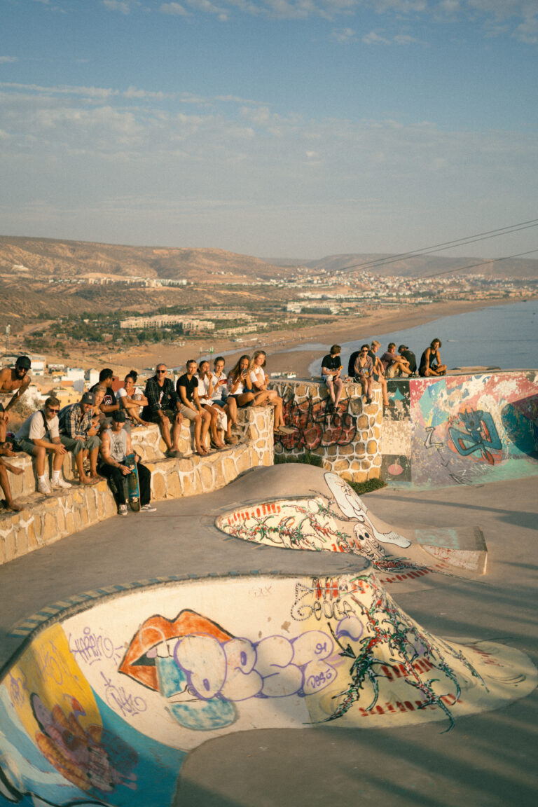 People sitting inTaghazout Skatepark at sunset
