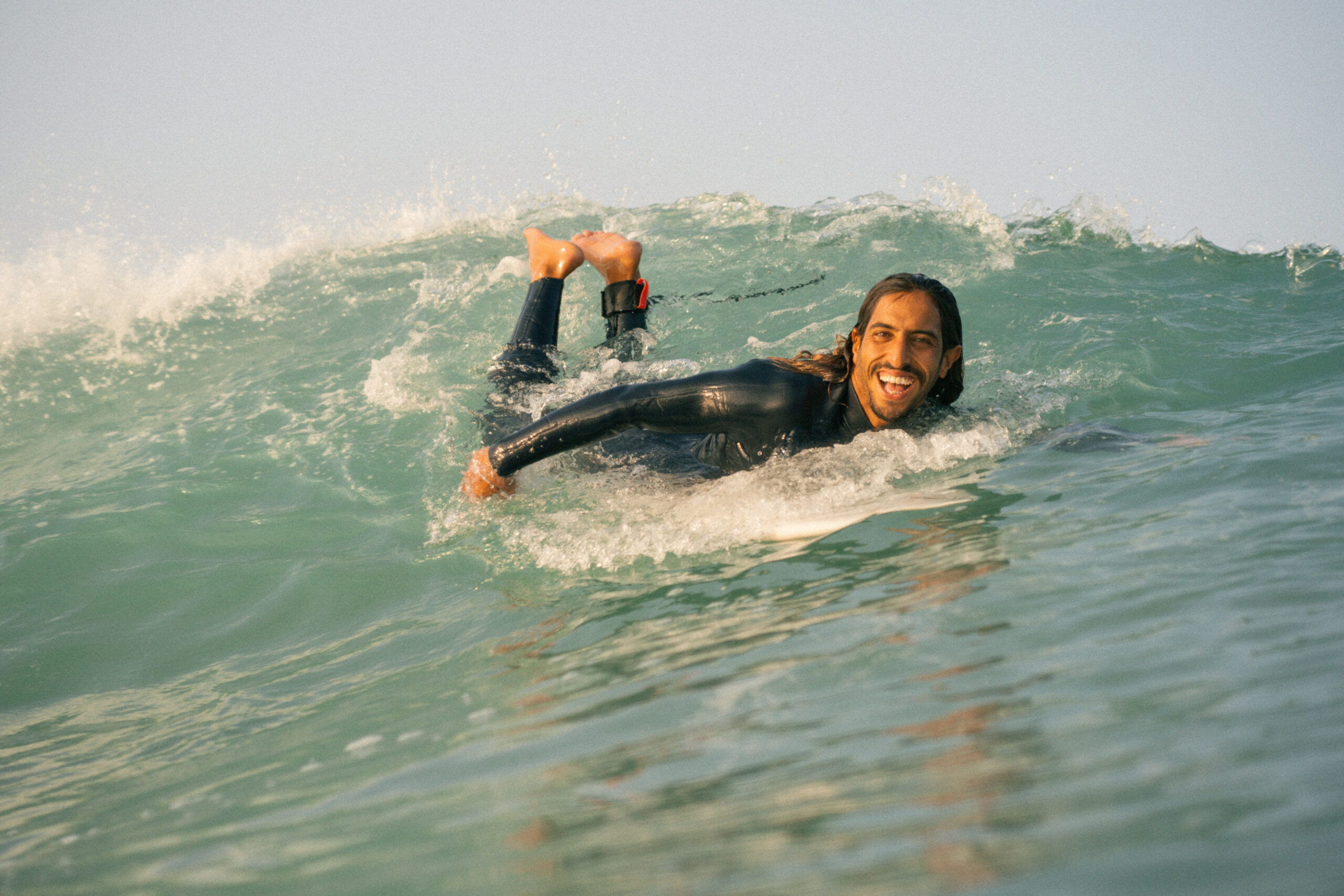 brahim on his surfboard at anza beach