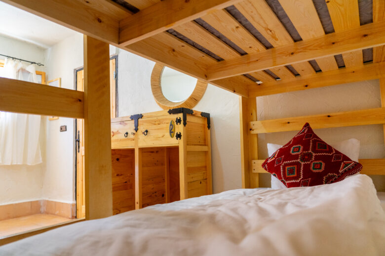 female dorm room at anza surfhouse; view from one of the bunk beds